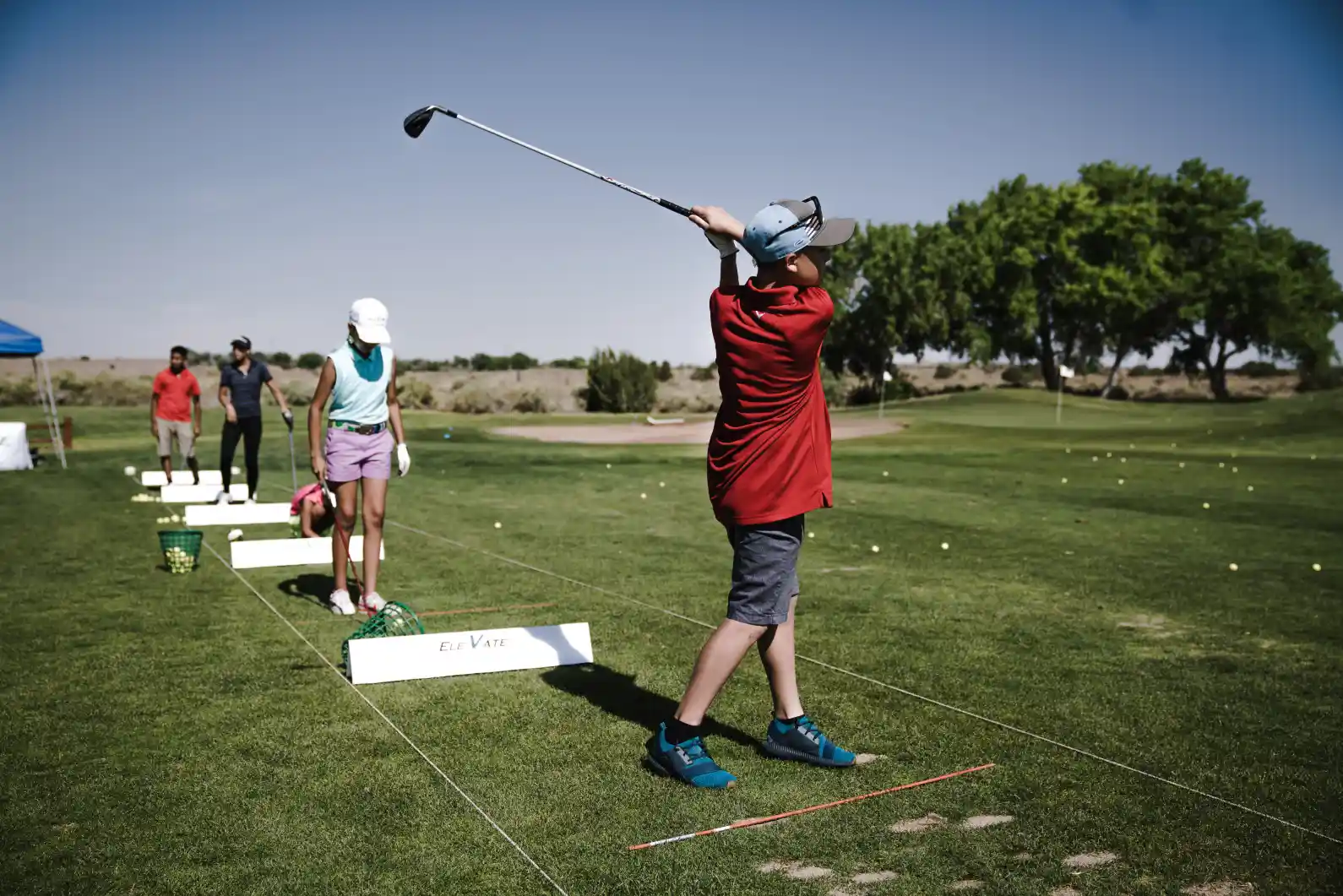Junior Tour Performance Golf Academy Students lined up with their golfing equipment.